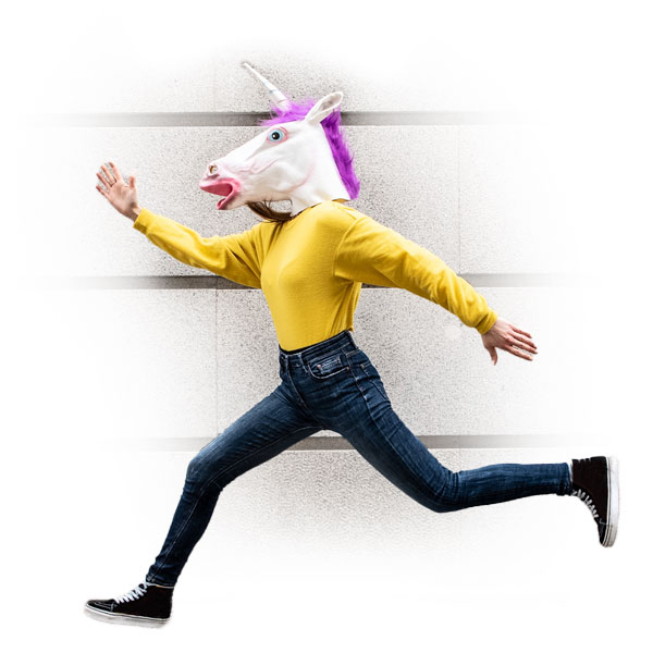 woman jumping with unicorn mask on